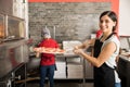 Pretty woman chef putting fresh made pizza in oven Royalty Free Stock Photo