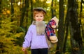 Smiling child boy in autumn forest. Little kid in autumn clothes play with teddy bear in park. Little boy playing in Royalty Free Stock Photo