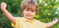 Smiling child boy. Cheerful cheerful kid. Happy children kid boy with hands up. Child outdoors in nature. Happy child Royalty Free Stock Photo