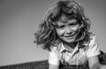 Smiling child boy enjoying on grass field and dreaming. Kids play on summer field. Royalty Free Stock Photo