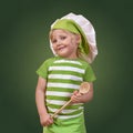 Smiling child chef with a big wooden spoon