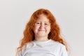 Smiling child. Cute little girl, kid with long curly red hair looking at camera isolated over white background. Concept Royalty Free Stock Photo