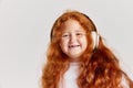 Smiling child. Cute little girl, kid with long curly red hair looking at camera isolated over white background. Concept Royalty Free Stock Photo