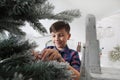 Smiling child decorate the christmas tree at home