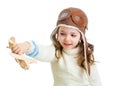 Smiling child dressed pilot and playing with wooden airplane toy Royalty Free Stock Photo