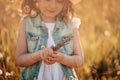 Smiling child girl holding bouquet on summer field