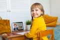 Smiling child girl learning at home. Little girl using tablet