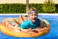 Smiling child looking at camera on a round float in a swimming pool Royalty Free Stock Photo