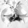 Smiling child lying on snow with copy space. Funny kid making snow angel. Child girl playing and making a snow angel in Royalty Free Stock Photo