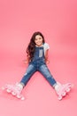 Smiling child in overalls and roller blades looking at camera