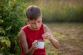 Smiling child picking and eating fresh ripe raspberries in the summer garden or backyard. Summertime harvest Royalty Free Stock Photo