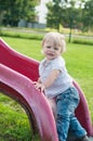 Smiling child playing on a baby slide