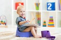 Smiling child sitting on chamber pot indoor Royalty Free Stock Photo