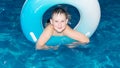 A smiling child swims in the water. Lifestyle and entertainment. Sports and recreation