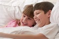Smiling children in bed playing. Close-up. Royalty Free Stock Photo