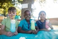 Smiling children with face paint having drinks at park Royalty Free Stock Photo