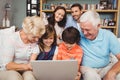 Smiling children and grandparents using laptop with family Royalty Free Stock Photo