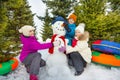 Smiling children make cute snowman in forest Royalty Free Stock Photo