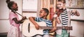 Children playing musical instruments in classroom