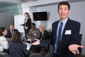 Smiling chinese businessman inviting to meeting room