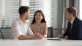 Smiling chinese young woman holding husbands hand, discussing bank loan.