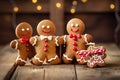 Smiling christmas gingerbread men and candy Canes at wooden table with Christmas lights in the background. Royalty Free Stock Photo