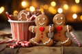 Smiling christmas gingerbread men and candy Canes at wooden table with Christmas lights in the background. Royalty Free Stock Photo