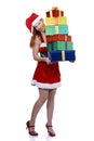 Smiling Christmas girl in Santa outfit with pile of gifts isolated on white, vertical Royalty Free Stock Photo