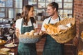 Smiling co-workers holding breads basket Royalty Free Stock Photo