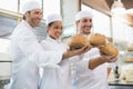 Smiling colleagues showing loaf of bread