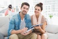 Smiling colleagues sitting on couch looking at camera