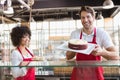 Smiling colleagues in uniform showing cakes