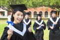 Smiling college graduate holds a diploma and thumb up Royalty Free Stock Photo