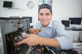 Smiling computer engineer working on broken console with screwdriver Royalty Free Stock Photo