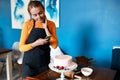 Smiling confectioner blogger holding smartphone in hand