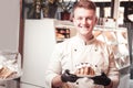 Smiling confectioner serving the croissant with a cream