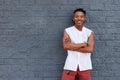 Smiling confident african man standing against gray wall