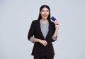 Smiling Confident Asian business woman showing credit card isolated on gray background Royalty Free Stock Photo