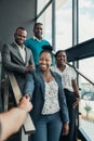 Smiling confident black businesswoman greeting and shaking hands with all African team