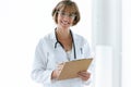 Smiling confident female doctor with eyeglasses looking at camera in the office at hospital. Royalty Free Stock Photo