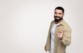 Smiling confident handsome young latin guy with a beard in casual point finger at camera Royalty Free Stock Photo