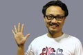 A smiling and confident manipuri north east indian man with spectacles showing the sign of five with fingers