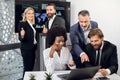 Smiling confident multiethnic business colleagues, working together over joint startup. Focus on mature blond woman and Royalty Free Stock Photo