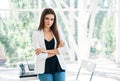 Smiling confident pretty businesswoman with crossed arms posing in a modern office