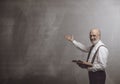 Smiling confident professor teaching and pointing at the blackboard