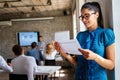 Smiling confident successful business woman leader standing in an office at team meeting. Royalty Free Stock Photo