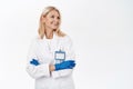 Smiling confident woman doctor, professional standing with arms crossed, wears medical gloves and clinic uniform, white Royalty Free Stock Photo