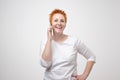 Smiling confident woman talking on cell phone over white background Royalty Free Stock Photo