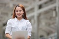 Smiling confident young Asian business woman using laptop for job at outside office Royalty Free Stock Photo