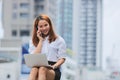Smiling confident young Asian business woman using laptop for job at outside office Royalty Free Stock Photo